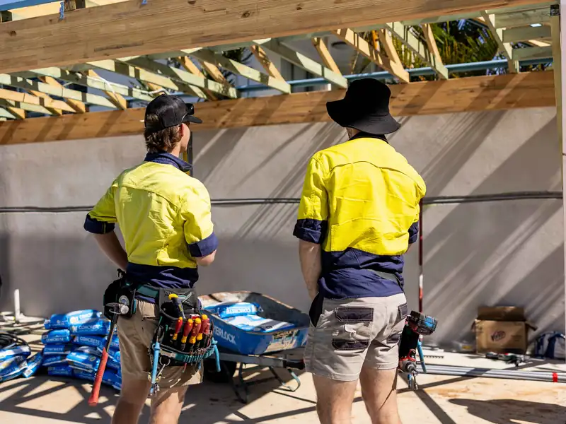 Two Hang Loose electricians in hi-vis on a home building site